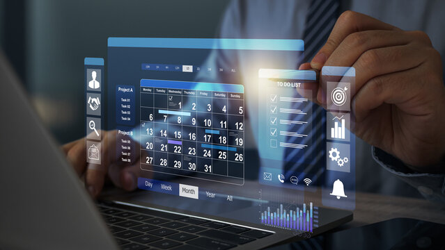 Businessman sitting with laptop on work calendar, Planning and Scheduling Calendar of meetings, events and activities Time management Notifications and reminders of important events.