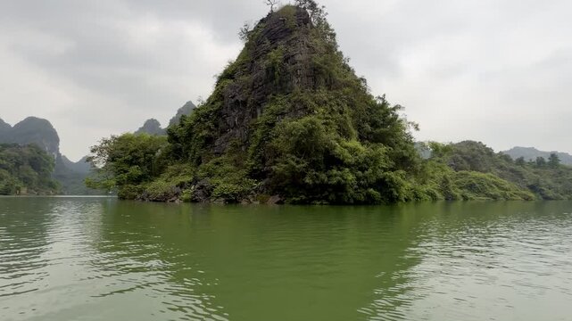 Ninh Binh, Trang An, scenic limestone karst mountain rising from tranquil green water in tropical bay, travel landscape, exploration, serenity, nature wilderness