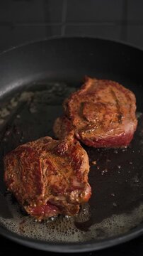Two lamb topside roast pieces searing on hot pan