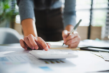 Hand presses calculator, focused on numbers