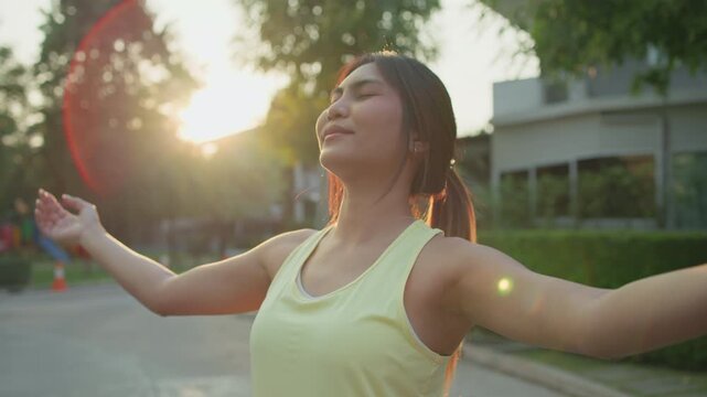 Asia young Gen Z people mindful happy woman open arm relax body deep stress relief outdoor nature green public park sun light self love anti aging life mental health care modern medical asian female.