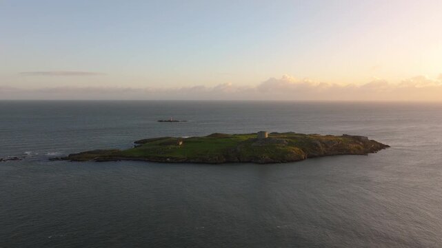 Dalkey Island with a historic Martello tower surrounded by calm seas at sunset. Ideal for travel and history footage.