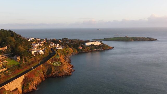 Charming coastal homes perched on cliffs with sweeping views of Dalkey Island and the ocean. Ideal for travel, real estate, and landscape projects.