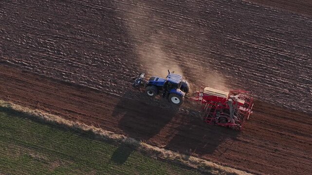 The tractor cultivates the field in spring. Aerial video. 4K 50fps