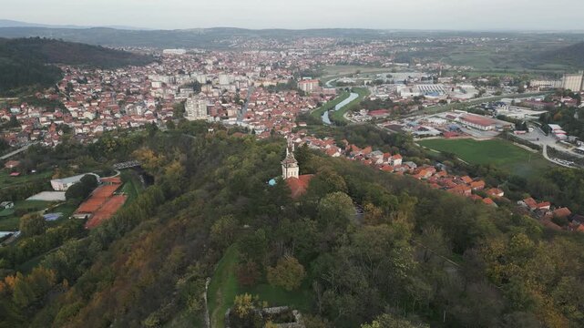 Aerial drone panorama of Prokuplje, Serbia, revealing town and surrounding green hills.
