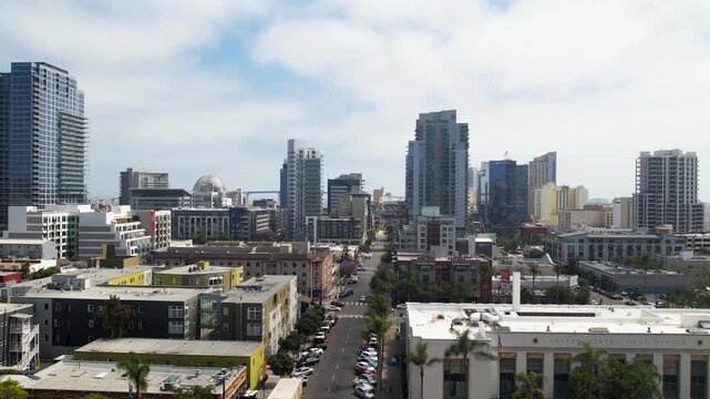 Drone flying south over 8th Street in downtown San Diego at 3PM moving toward Petco Park with urban buildings and streets below.