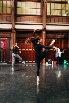 Two dancers rehearsing graceful movements in historic studio hall