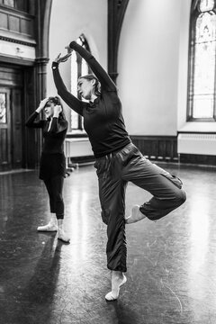 Dancers rehearsing ballet movements in large studio