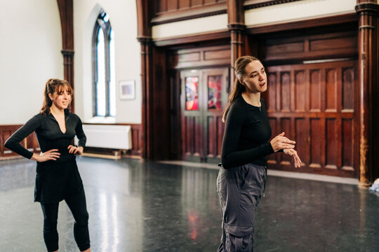 Two dancers discussing rehearsal in historic studio hall