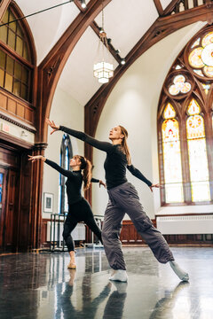 Dancers rehearsing graceful performance in beautiful studio space