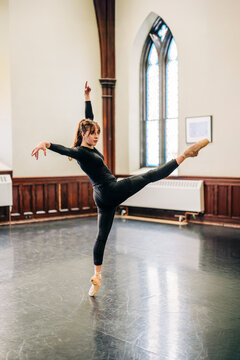 Ballet dancer performing arabesque in pointe shoes
