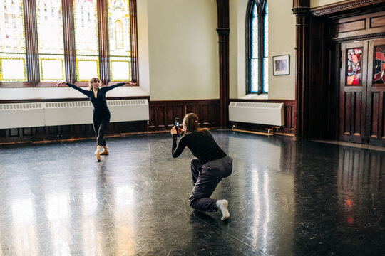 Dancer practicing ballet while artist capturing performance