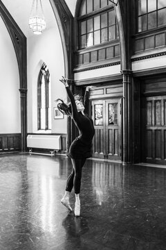 Ballerina dancing in pointe shoes gracefully moving indoors