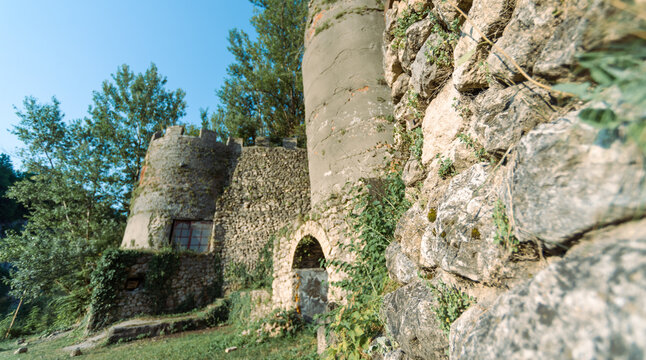 old antique castle with a fortress wall and towers in a forest