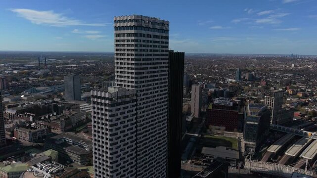 Croydon skyscrapers in city center above train station. Close-up aerial view in circular motion. Urban are with modern architecture of high rise buildings. Panoramic view towards London on a sunny day