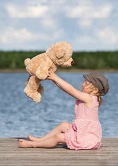 little girl sitting on the pier with her teddy © Jenny Sturm