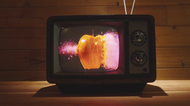 Old Vintage 80's Television with Bullet going through Apple in Slow Motion