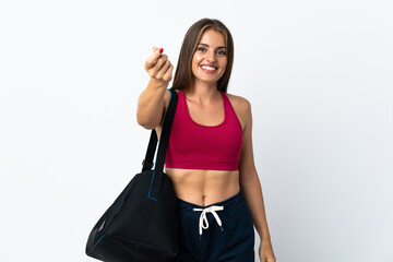 Young sport Uruguayan woman with sport bag isolated on white background making money gesture