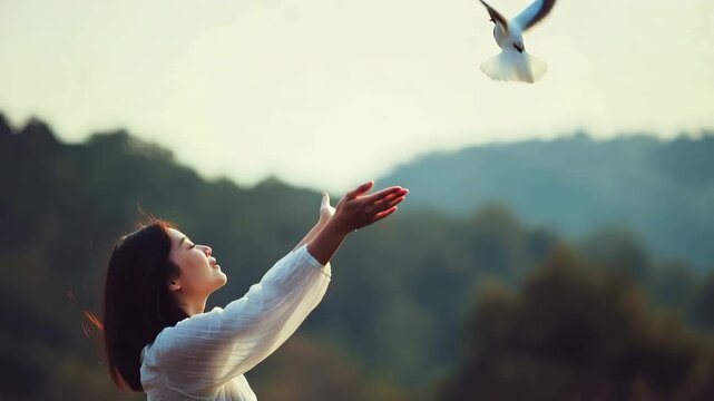 A wild bird and a woman in prayer appreciating the backdrop of nature and the idea of hope