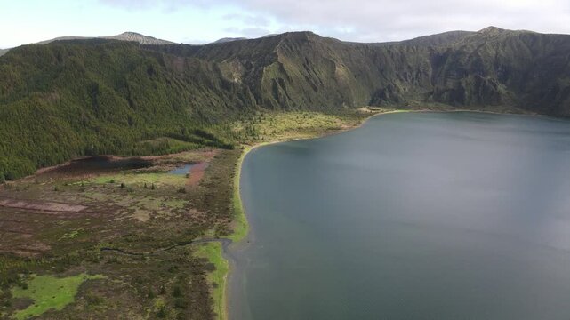 Aerial drone flight over Lagoa do Fogo crater lake with forward motion and smooth right pan, Sao Miguel, Azores.