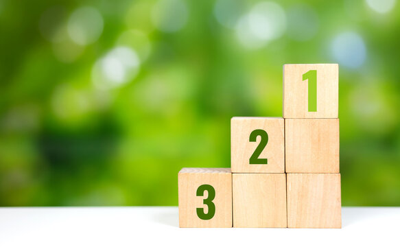 Wooden blocks with numbers 1, 2, 3 arranged as steps, representing progress and achievement. Step by step progress and achievement concept