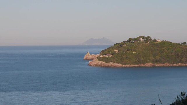 Cliff in the coastline of Lazio region at sunrise with the promontory od Circeo in the background, Italy