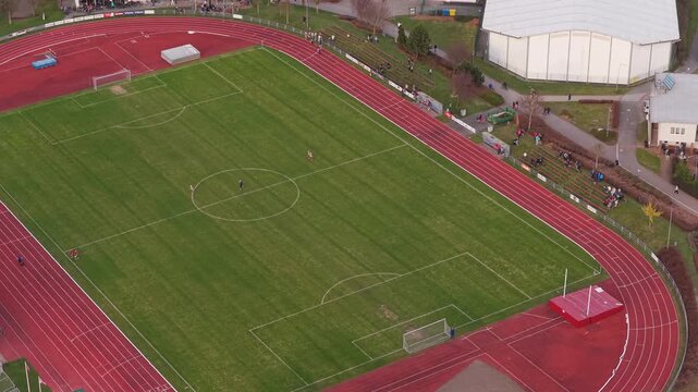Aerial view of football stadium in Svitavy as players leave field.
City scene captured by drone after match.