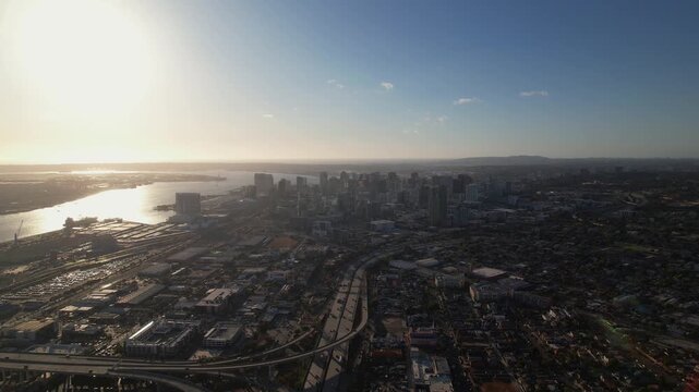 Drone pulling back at 6PM facing downtown San Diego capturing a wide view of the skyline and city layout.