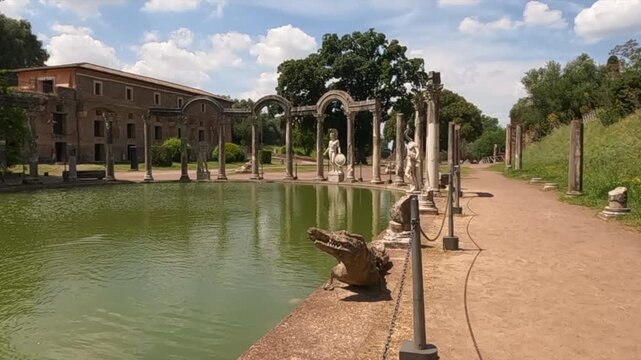Cinematic zoom out reveals the Canopus pool at Hadrians Villa in Tivoli, Rome, Italy, showcasing ancient Roman columns, marble statues, and serene reflective water.