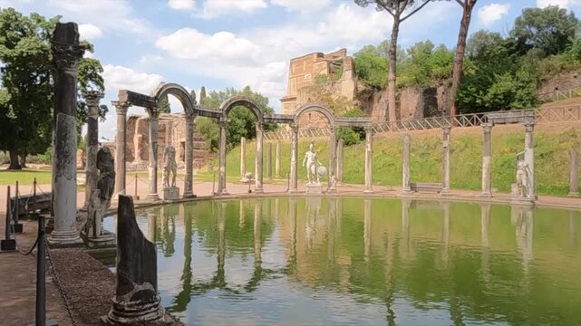 View of the Canopus at Villa Adriana in Tivoli, Italy. Ancient Roman columns, marble statues, and reflecting pool surrounded by lush greenery at Hadrian's Villa UNESCO site.