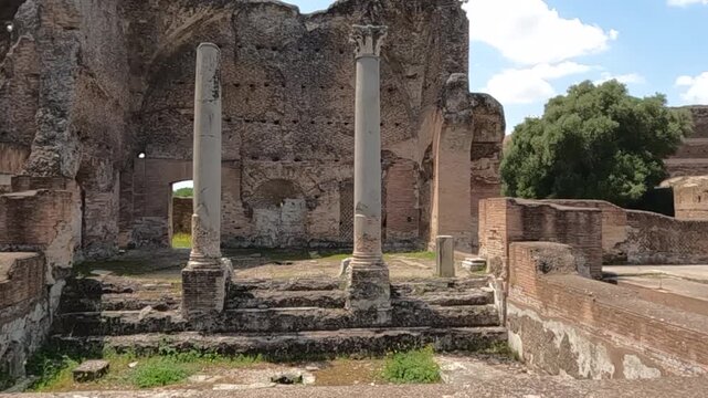 Standing columns and crumbling brick walls at Villa Adriana, Hadrian's Villa near Rome, Italy. Ancient Roman architecture bathed in natural sunlight.