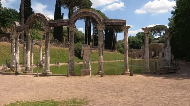 Canopus pool and ancient Roman colonnades at Villa Adriana, Hadrian's Villa near Tivoli, Italy. UNESCO World Heritage Site with marble statues and arches.