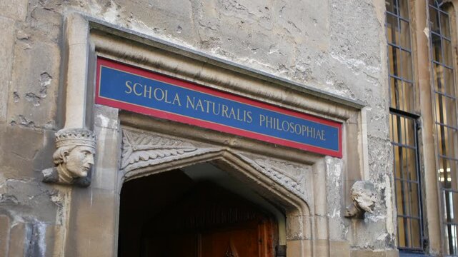 An ancient Oxford University stone doorway with "SCHOLA NATURALIS PHILOSOPHIAE" School of Natural Philosophy above, flanked by carved heads&mdash;perfect for academic, historical tourism, or educational