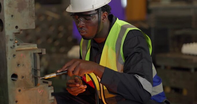 A technician performs precision grinding and close inspection on a metal component in a manufacturing facility, showing finishing work, process control, and industrial supervision.
