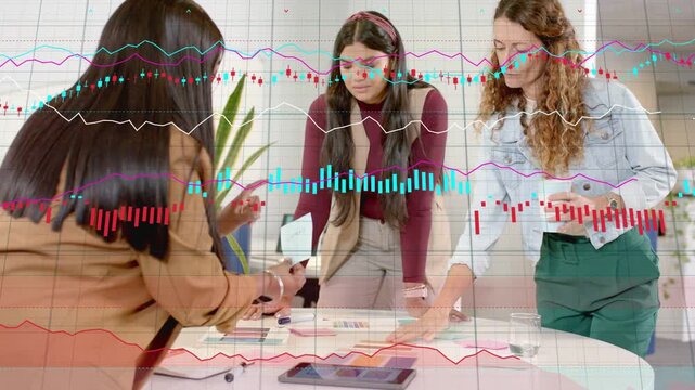 3 women reviewing layouts at table, left tapping phone, animated charts growing over tablet design