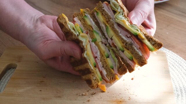 Club sandwiches with guacamole and fresh vegetables show the cut