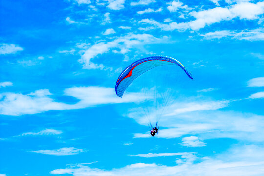 Skydiving using a parachute when the blue sky