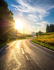 Fototapeta premium Scenic Winding Asphalt Road At Sunset With Golden Sunlight Lens Flare And Rolling Green Hills Under A Blue With Clouds In The Countryside
