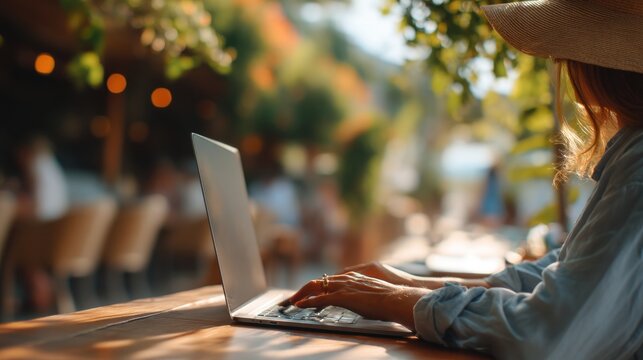 Woman using laptop outdoors at cafe