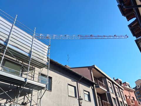 Lavori in corso nel cantiere edile in primavera - gru e ponteggio