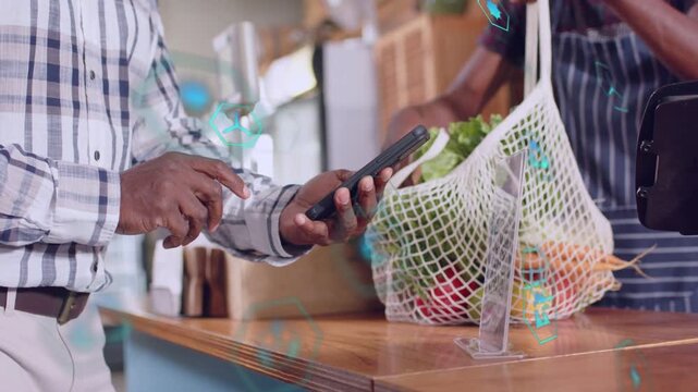 Customer tapping phone, starting mobile pay, teal UI animating around phone as cashier handing bag