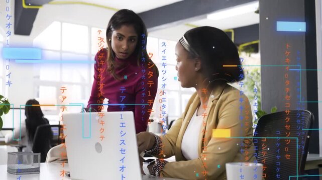 Woman leaning and pointing at laptop, colleague typing as code overlays guiding business review