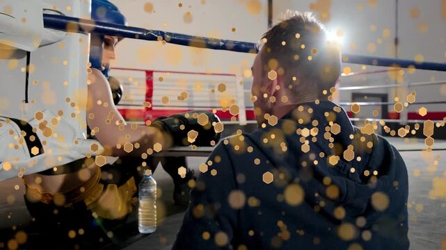 Boxing coach handing bottle female boxer pushing up using ropes rejoining ring gold circles overlay