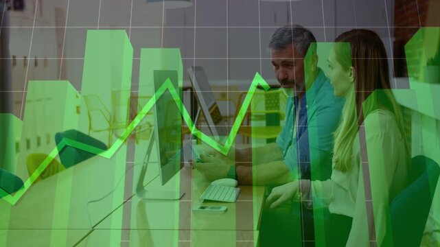 Male mentor tapping tablet and causing green chart overlay while guiding mentee in business review