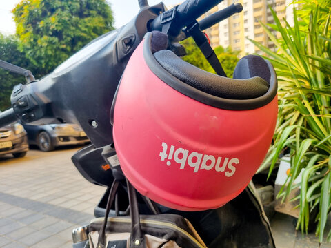 Gurgaon, Delhi, India - 15th oct 2025: Pink helmet of Indian quick home service startup Snabbit on an electric vehicle with female rider