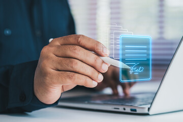 Fototapeta premium Business professional using digital pen signing electronic document on laptop, virtual interface, e-signature technology concept, secure online contracts, paperless workflow, digital transformation
