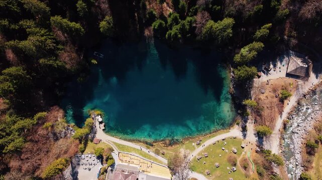 Aerial: Blausee in Bernese Oberland during the day in Kandergrund, canton of Bern, Switzerland, spiral top down drone shot