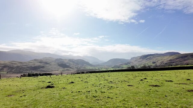Rolling green hills in the Lake District, Keswick, under a bright blue sky. POV, push forward shot