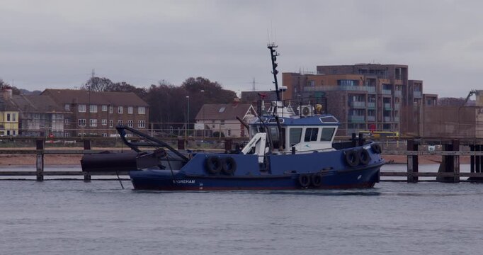 Wide shot of a tugboat entering Shoreham harbour