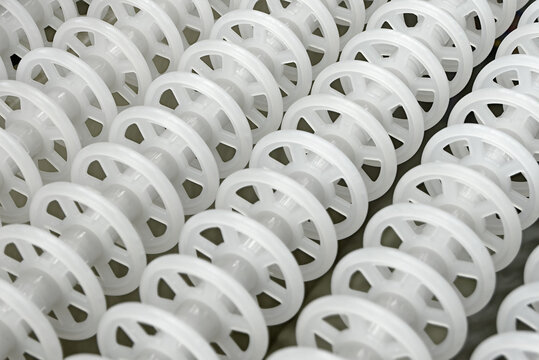White plastic rollers of industrial conveyor, production, sorting, or transportation line